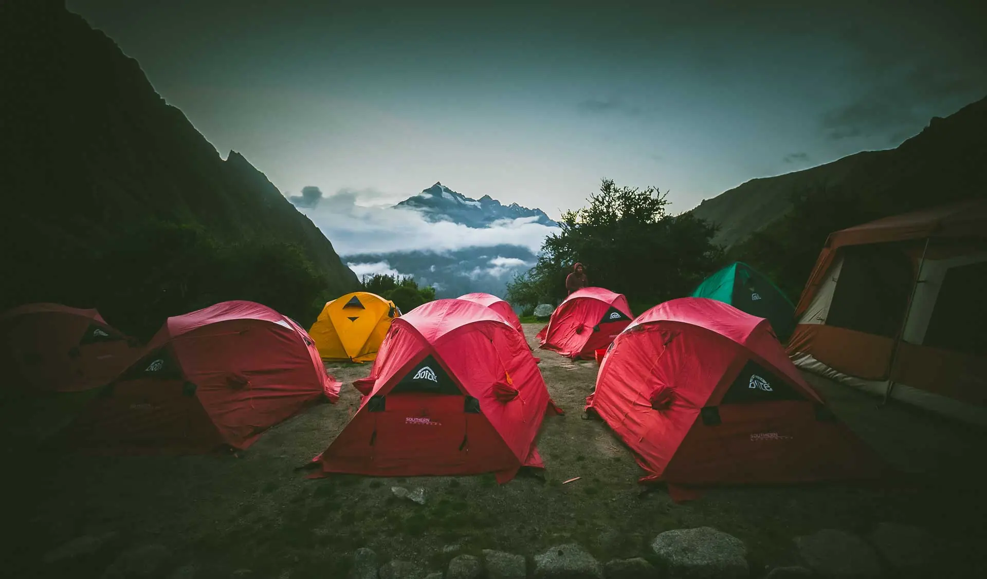Inca Trail campsite with red tents and snowy Andean peaks