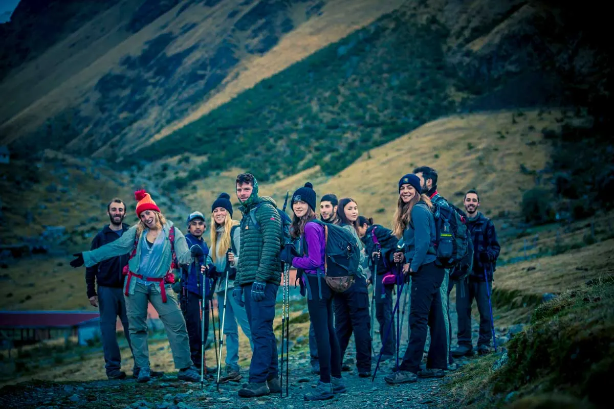 Trekking group standing together at dusk in the mountains