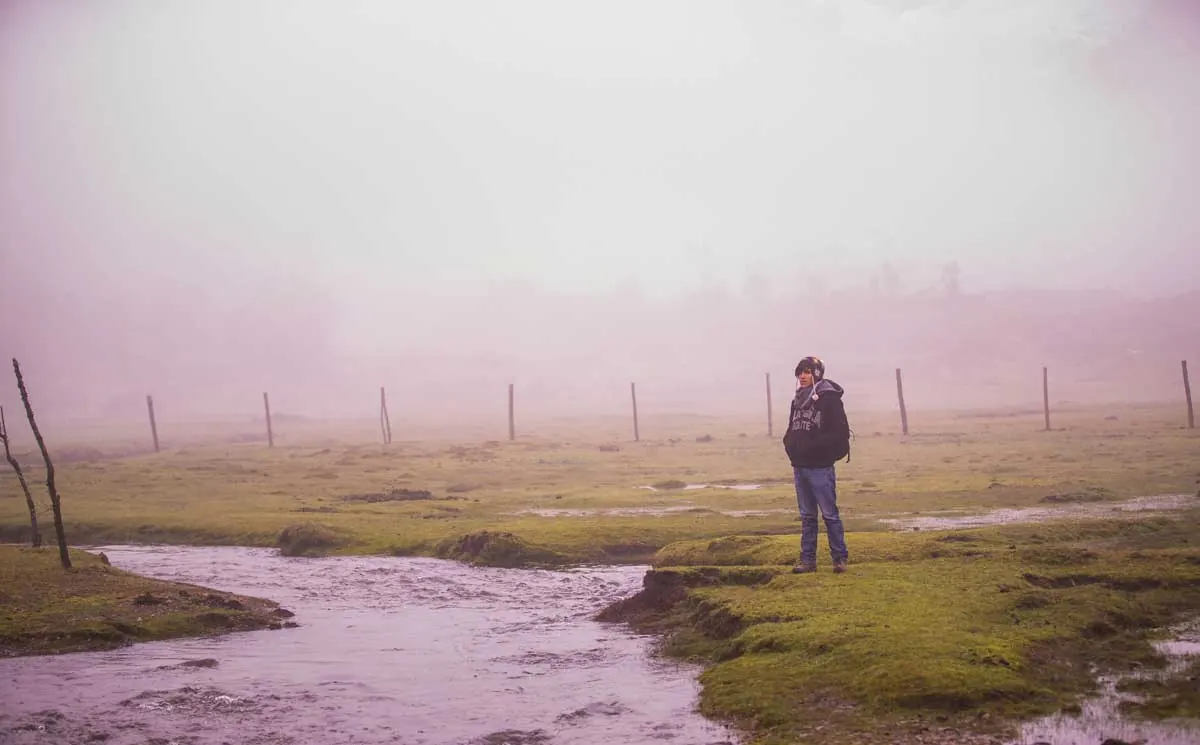Joel Cárdenas Gonzales, founder of Southern Peru Explorers, beside a stream in a misty highland valley
