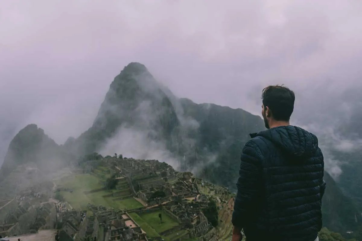 Traveler looking at Machu Picchu in the mist