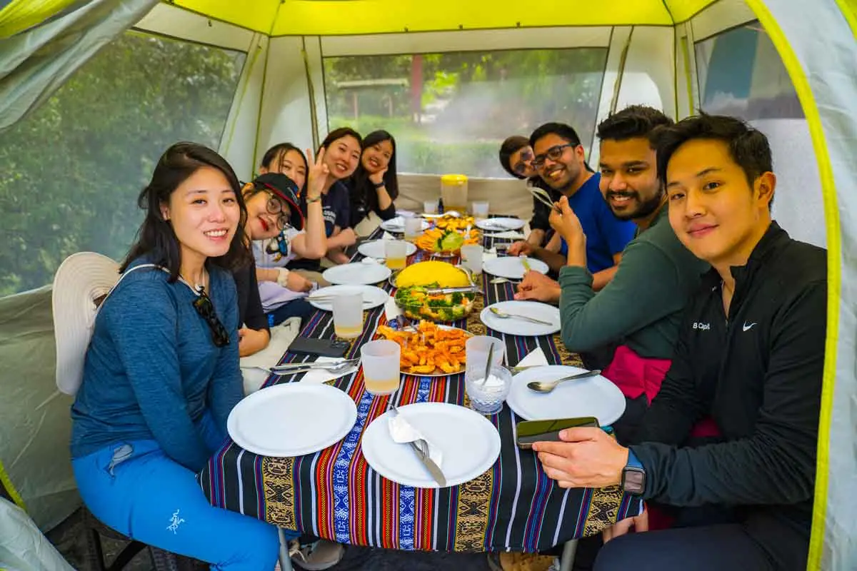 Trekkers smiling around the table in the dining tent