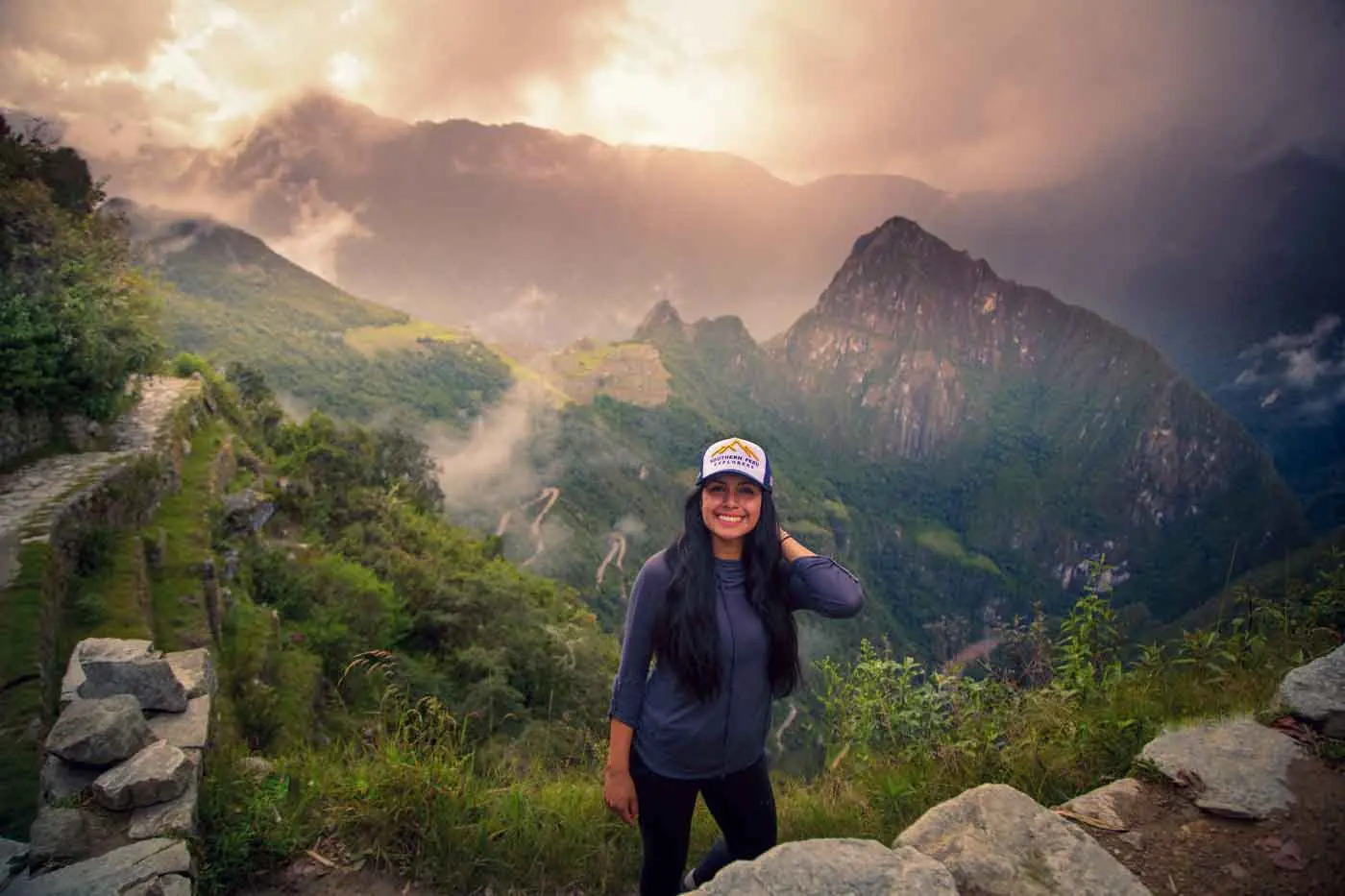 Hiker at Inti Punku (Sun Gate) with Machu Picchu mountains behind