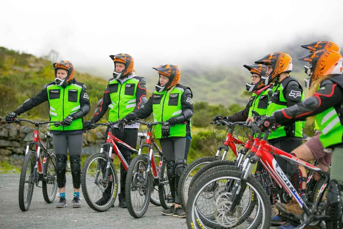 Group of bikers in safety vests with their bikes before the descent