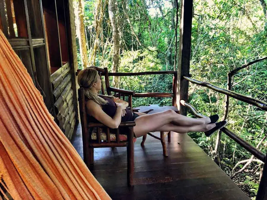 Traveler relaxing on a lodge balcony surrounded by forest