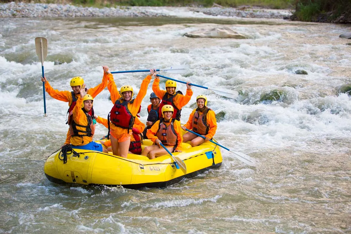 Rafting group raising their paddles on the river