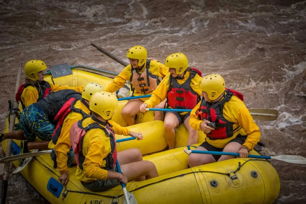 Rafting group paddling a yellow raft on the river