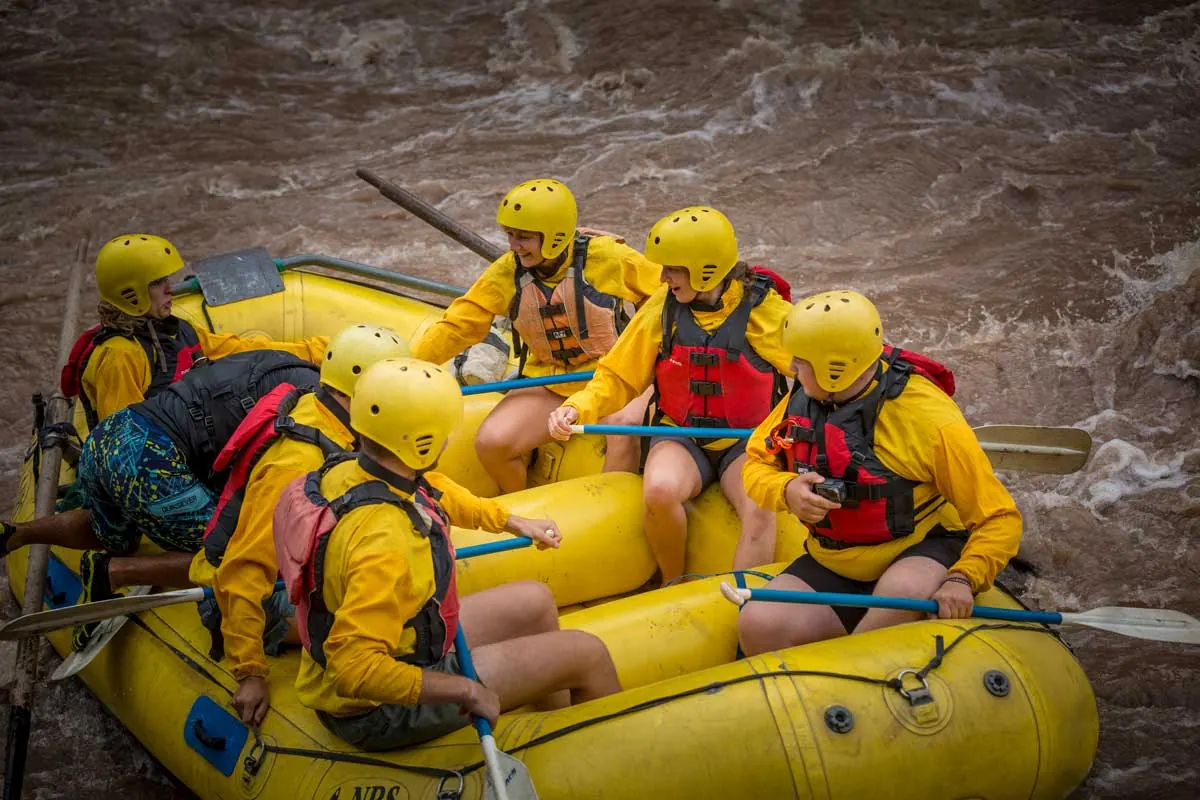 Rafting group paddling a yellow raft on the river