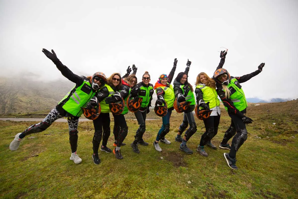 Bikers in green vests jumping for a group photo