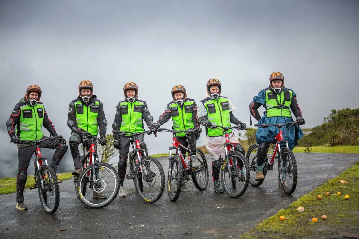 Group of bikers in green vests standing with their bikes on the road