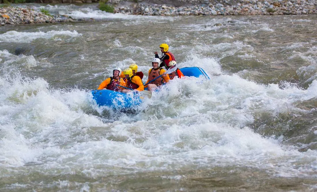Rafters in a blue raft on rough white water