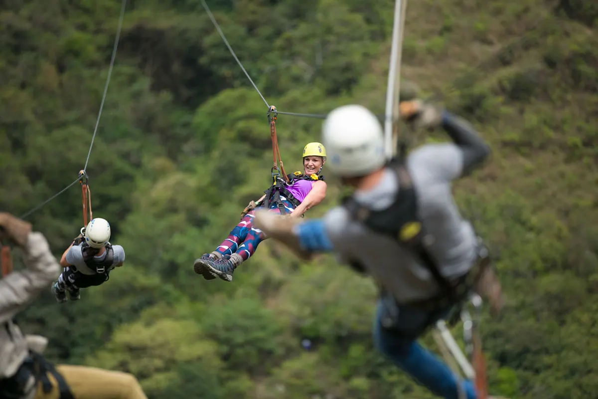 Zipline guide and a rider above the forest